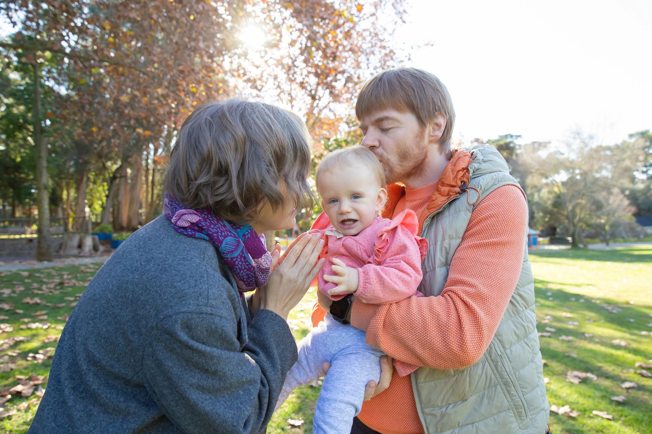 Parents holding a baby outdoors